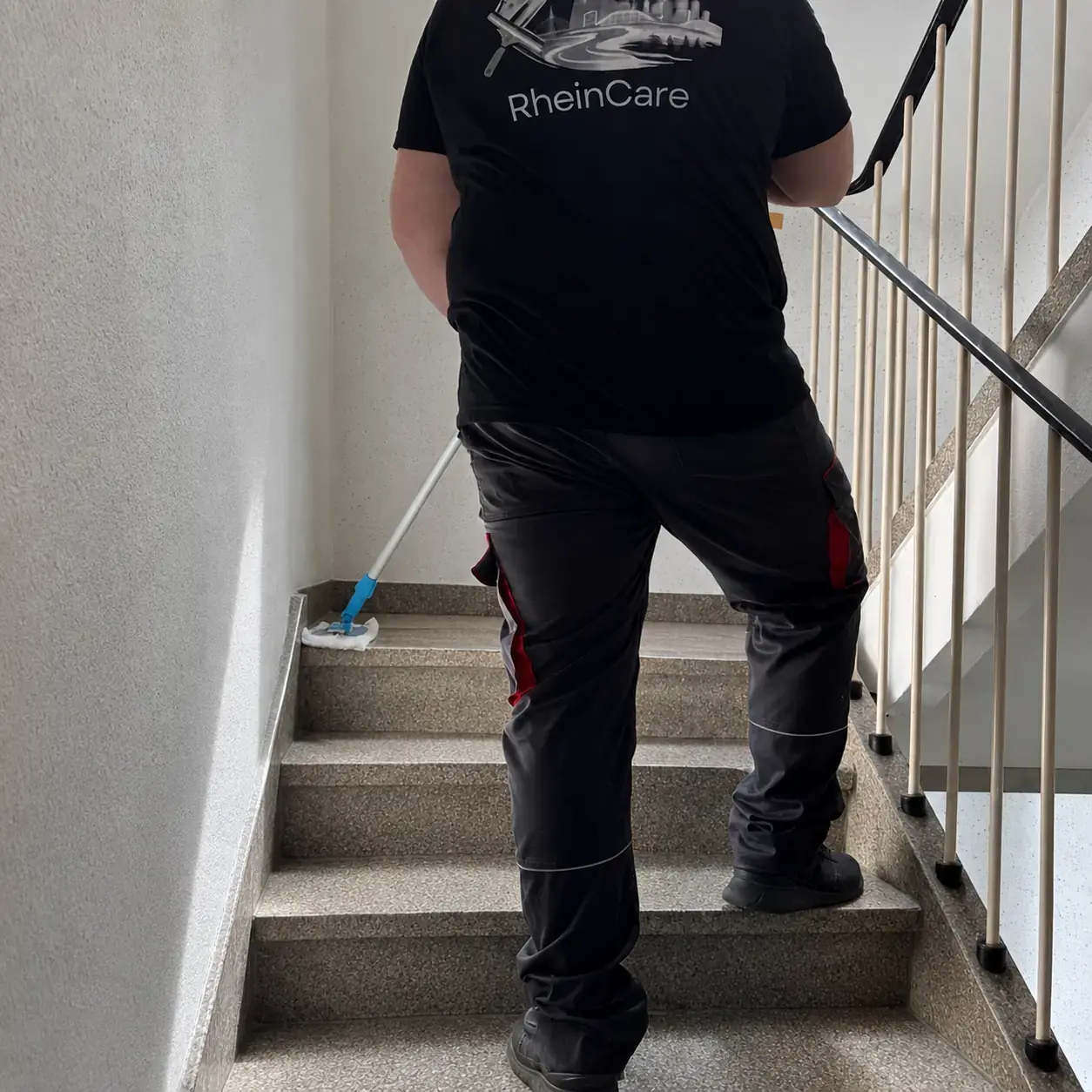 RheinCare Mitarbeiter bei einer Treppenhausreinigung